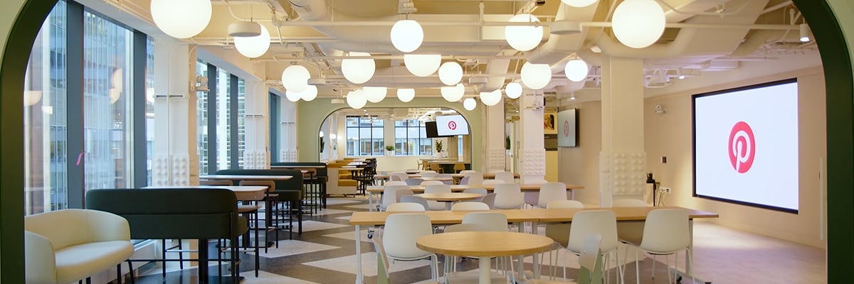 다양한 테이블과 스크린이 있는 Pinterest 본사 내부 모습